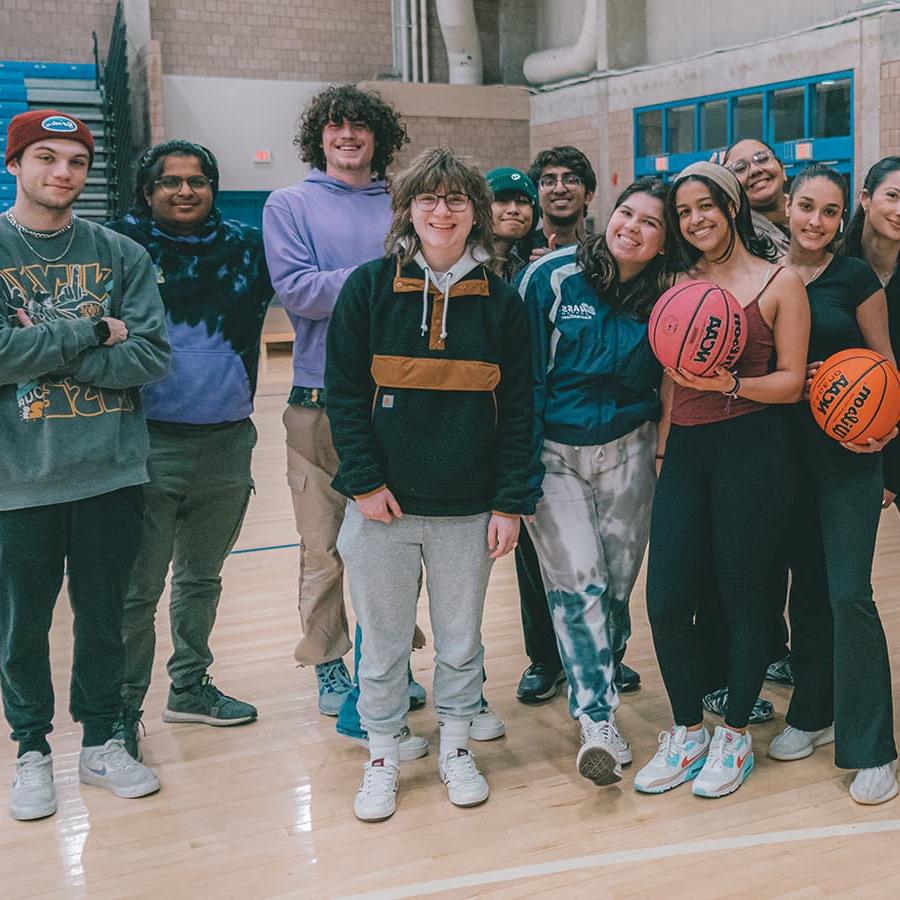 Group of students pose with basketball.